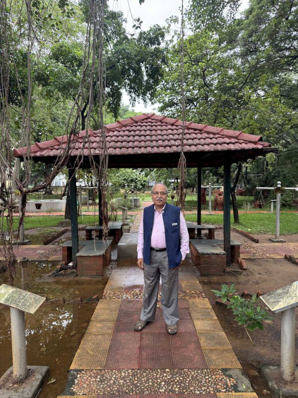 Satish Balram Agnihotri, standing in a garden
